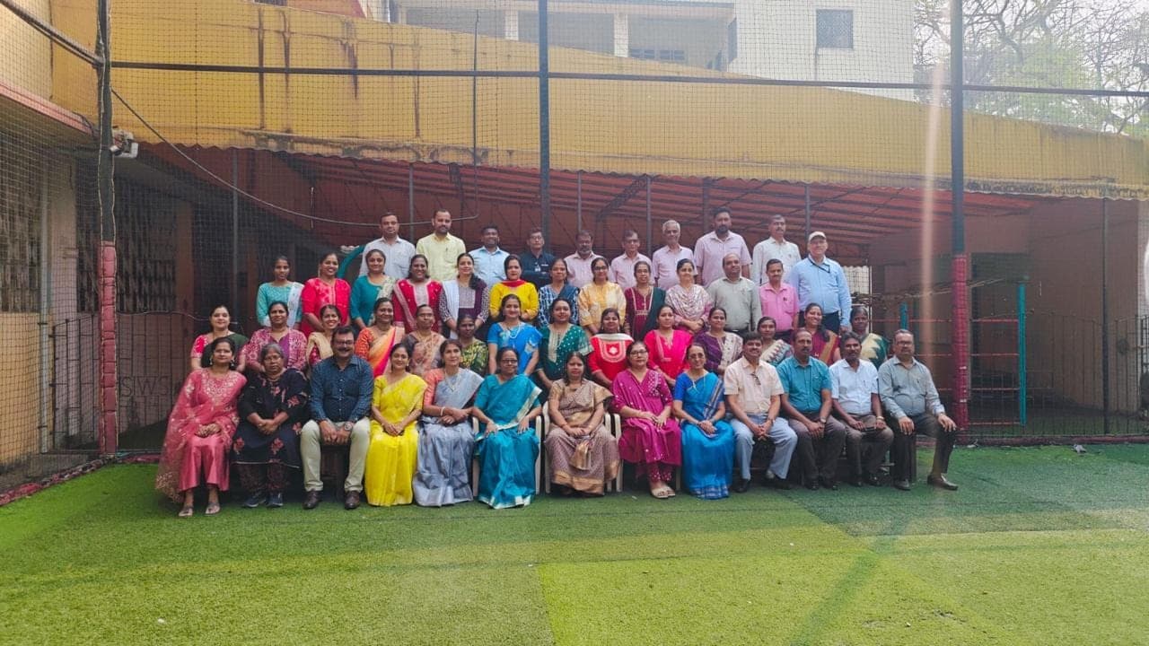 The teaching staff of SIWS Secondary School assembled on the turf pitch.