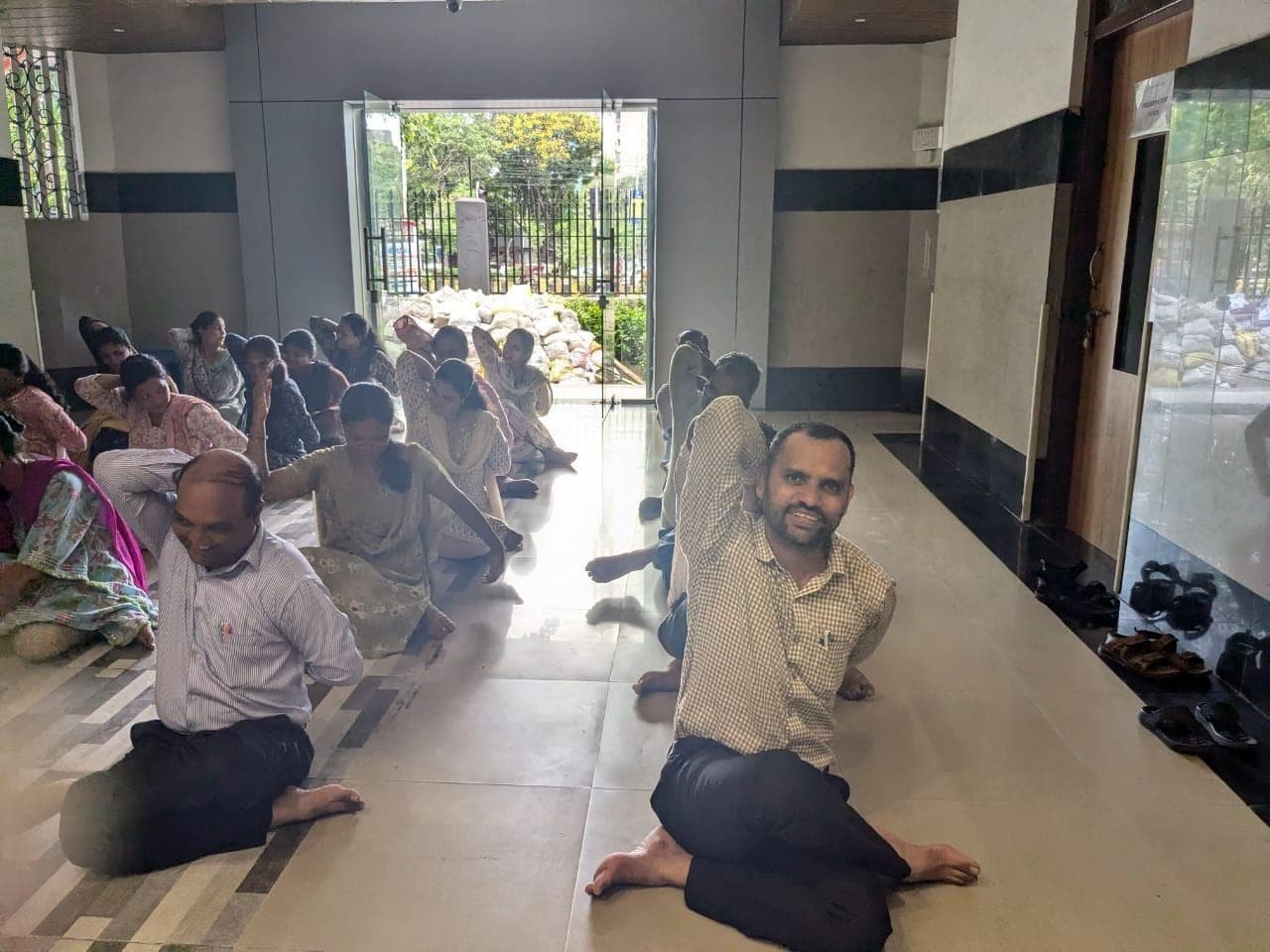 Staff taking part in a yoga session in the school hall.