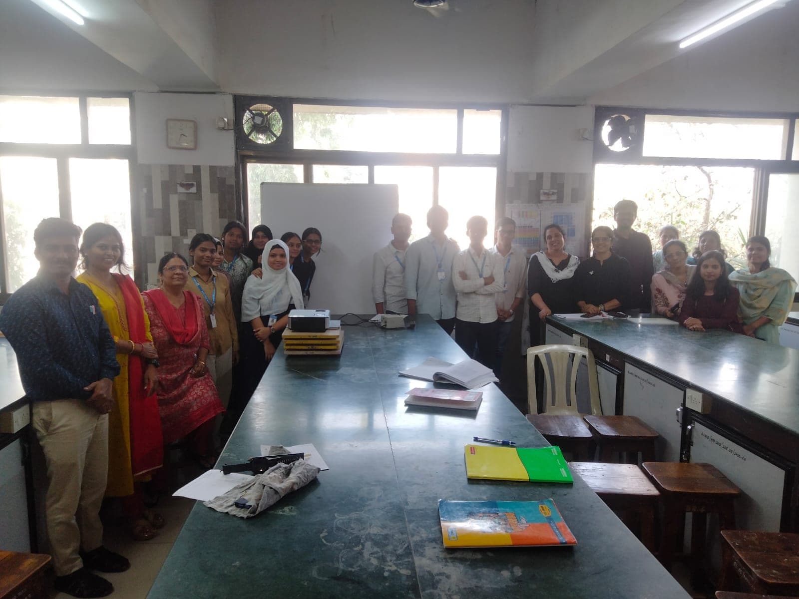 Students and teaching staff of the Physics department standing together along the laboratory benches.