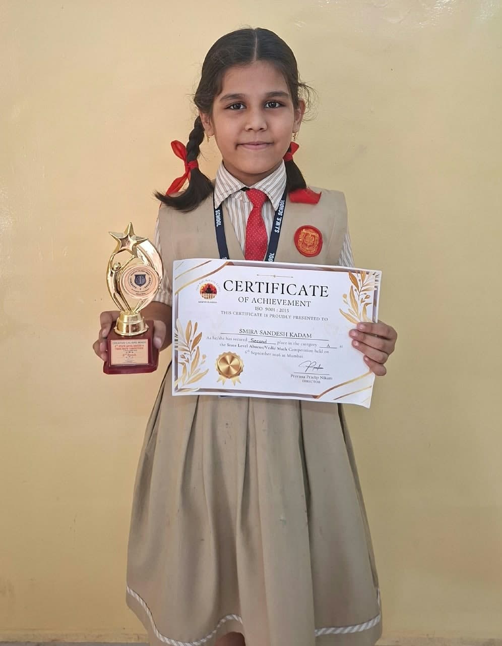 Smira Sandesh Kadam of the Primary Section in school uniform, holding a trophy and her certificate for second place in the State Level Abacus/Vedic Math Competition, Mumbai, 6 September 2026.